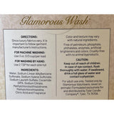 A close-up of the back of a Glamorous Wash laundry detergent package, showing product directions, ingredients, and caution text on a cream background with a subtle damask pattern and the brand name at the top.